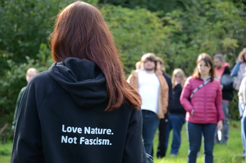 Es ist ein Backprint eines Pullovers mit der Aufschrift "Love Nature. Not Facism." zu sehen.